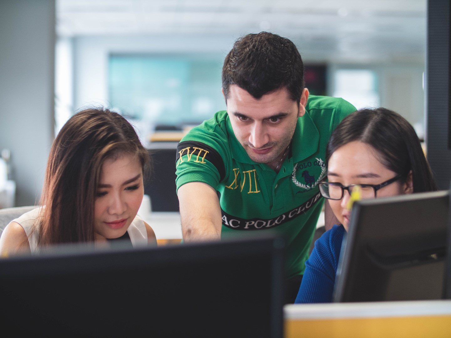 multiple users in front of a monitor, probably looking at the integrated ai product assistant